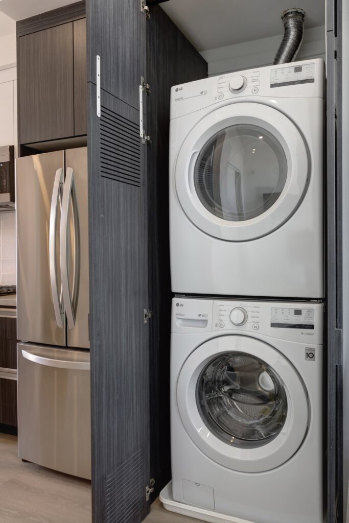 kitchen area view of laundry stackable washer and dryer