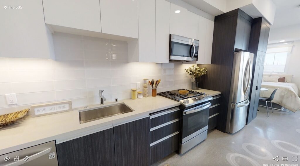kitchen with under cabinet lighting, stainless steel appliances, and light and dark cabinets