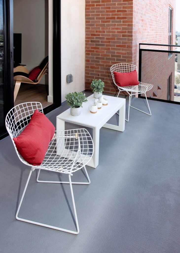 Outdoor balcony with lounge seating, coffee table, and access to indoor apartment