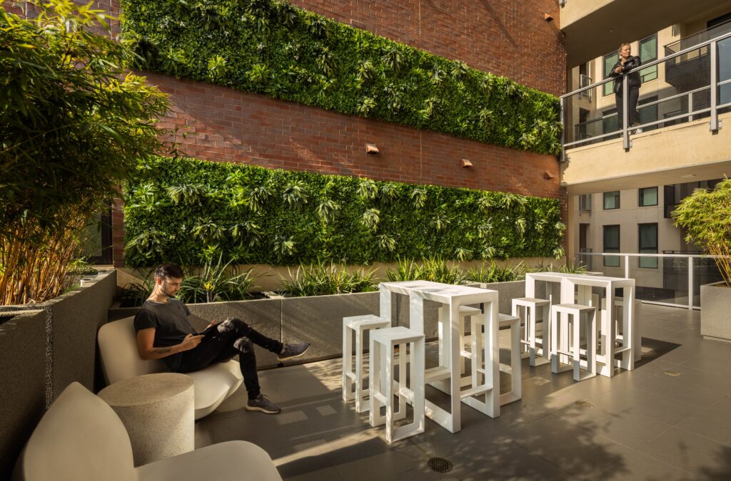 Outdoor courtyard with seating, surrounding botanical gardens
